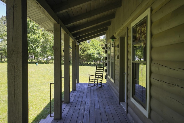 wooden deck featuring a porch and a yard