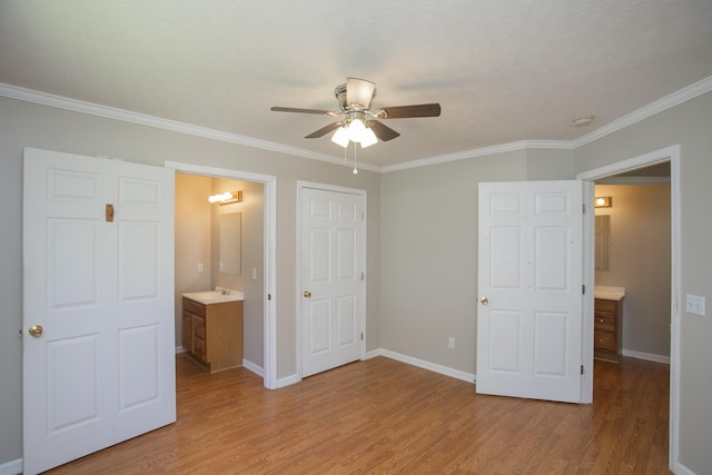 unfurnished bedroom featuring light hardwood / wood-style floors, ensuite bath, ceiling fan, and crown molding