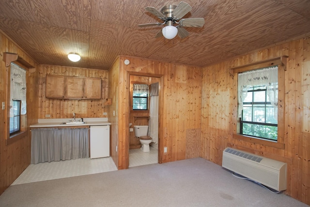 kitchen featuring wooden walls, wooden ceiling, a wall unit AC, and white dishwasher