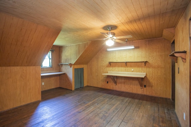 additional living space with wooden walls, ceiling fan, and dark hardwood / wood-style floors