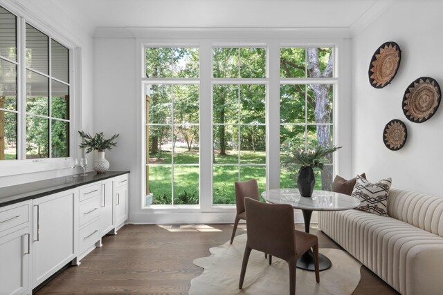 dining room featuring crown molding, a wealth of natural light, and dark hardwood / wood-style flooring