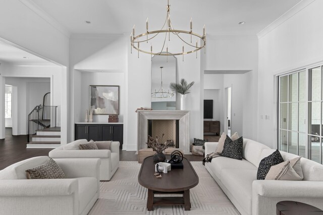 living room with a notable chandelier, plenty of natural light, crown molding, and hardwood / wood-style floors