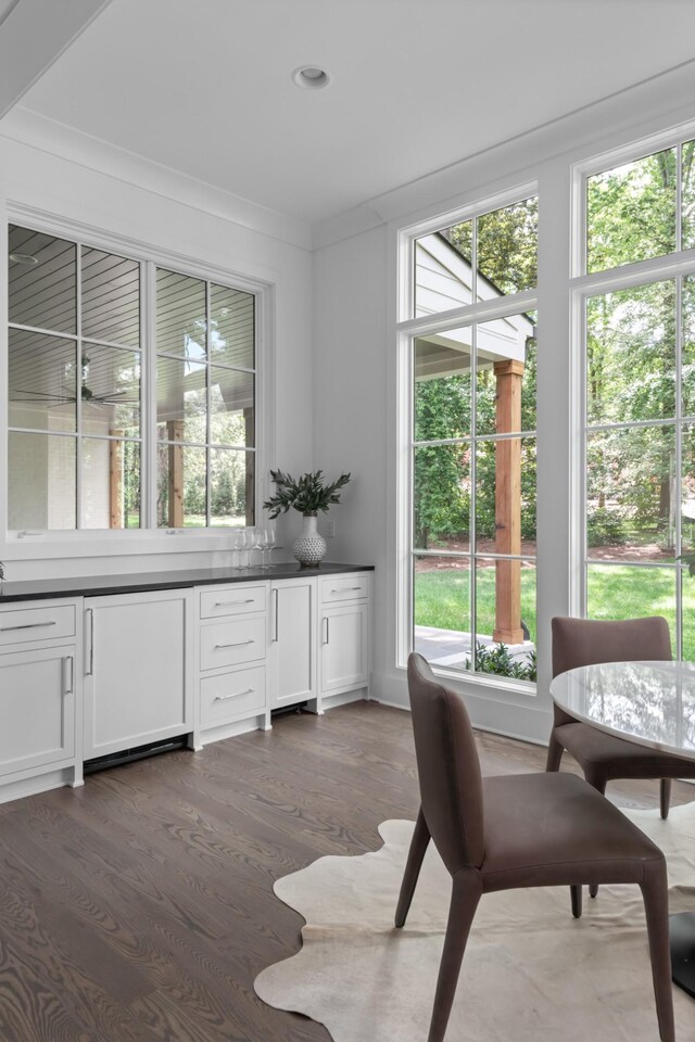 dining space featuring a wealth of natural light, dark hardwood / wood-style floors, and crown molding