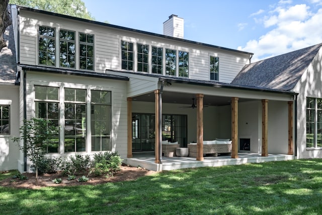 back of house with ceiling fan, a lawn, and an outdoor hangout area