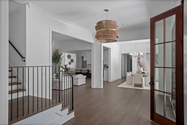 foyer entrance featuring a chandelier, dark hardwood / wood-style floors, and crown molding