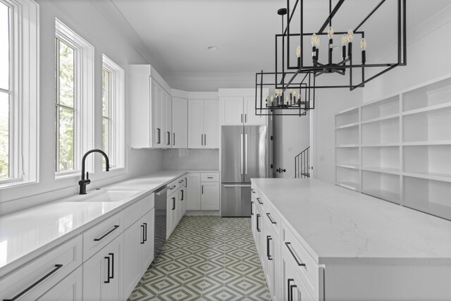 kitchen featuring stainless steel appliances, sink, plenty of natural light, and light tile floors