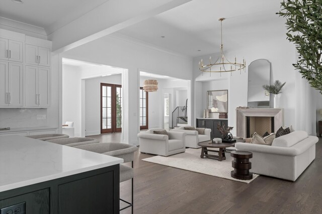 living room featuring a notable chandelier and dark wood-type flooring