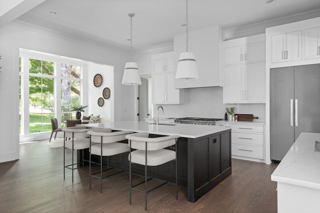 kitchen featuring dark hardwood / wood-style floors, plenty of natural light, a center island with sink, and high end refrigerator