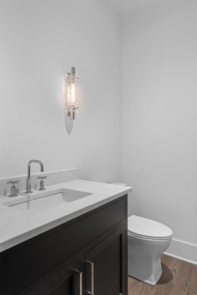 bathroom featuring wood-type flooring, vanity, and toilet