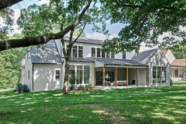 rear view of property with a lawn