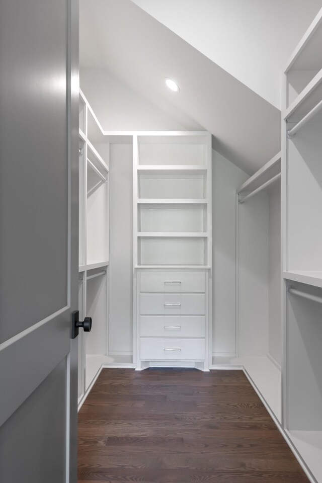 walk in closet featuring dark hardwood / wood-style floors and vaulted ceiling