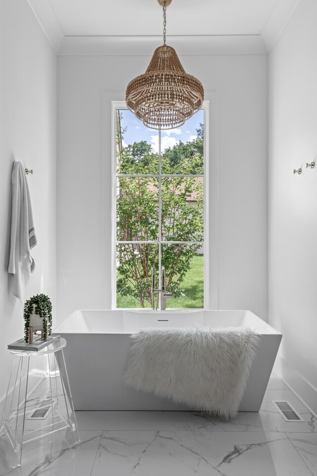 bathroom with a notable chandelier, ornamental molding, and tile floors