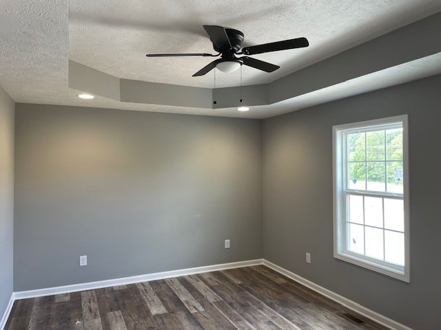 unfurnished room featuring dark wood-type flooring, a textured ceiling, and ceiling fan