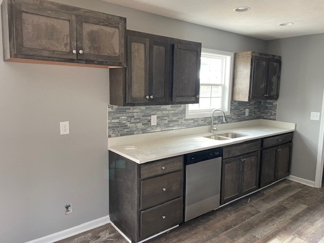 kitchen featuring dark hardwood / wood-style floors, tasteful backsplash, sink, stainless steel dishwasher, and dark brown cabinetry