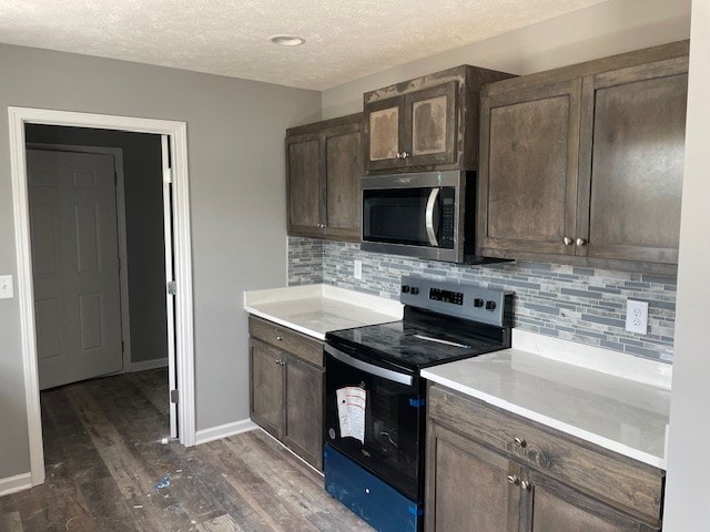 kitchen with dark hardwood / wood-style floors, electric range oven, tasteful backsplash, dark brown cabinetry, and a textured ceiling