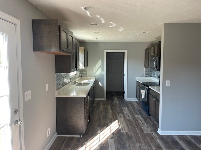 kitchen with dark brown cabinetry, sink, black / electric stove, dark hardwood / wood-style flooring, and decorative backsplash