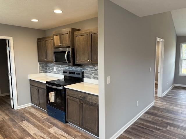 kitchen featuring black electric range, dark hardwood / wood-style floors, and decorative backsplash