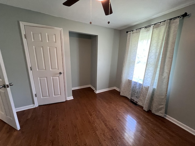 unfurnished bedroom featuring a closet, dark hardwood / wood-style floors, and ceiling fan