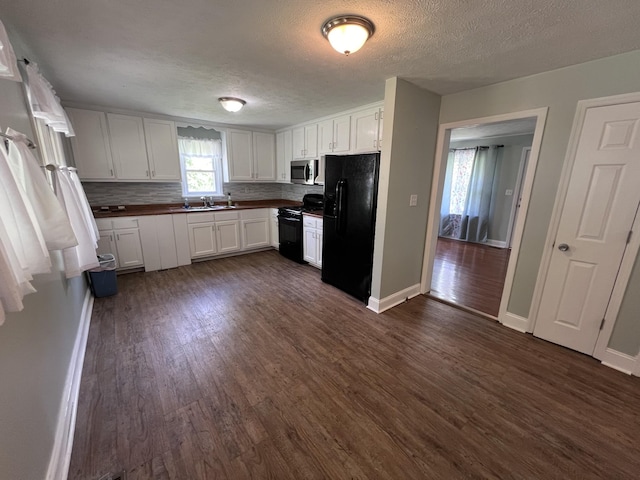 kitchen with black appliances, decorative backsplash, white cabinets, and dark wood-type flooring