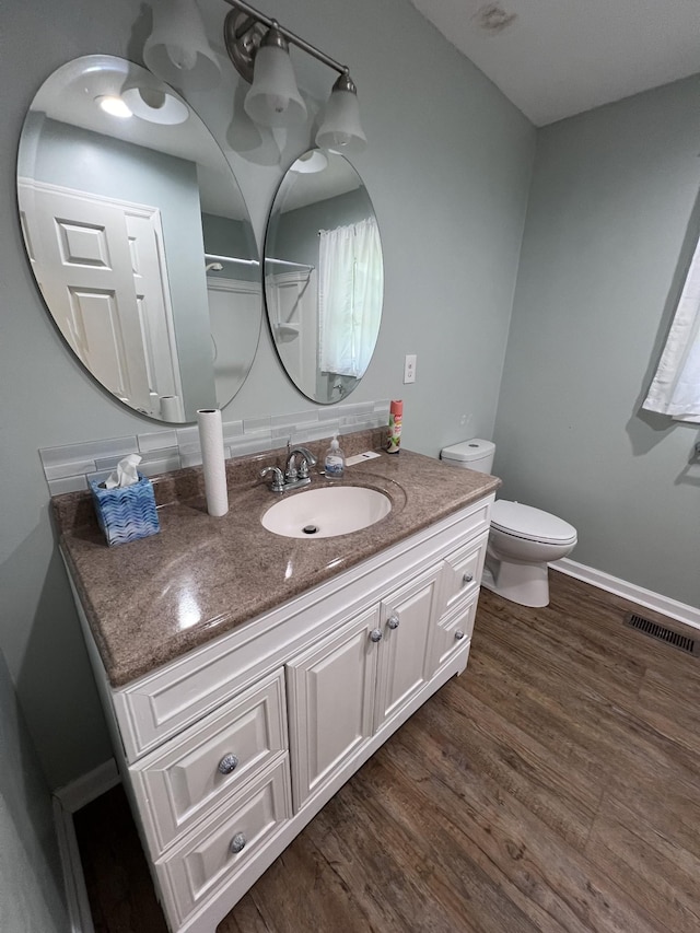 bathroom with hardwood / wood-style floors, vanity, and toilet