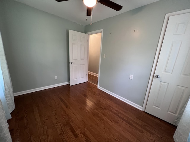 unfurnished bedroom featuring ceiling fan and dark hardwood / wood-style floors