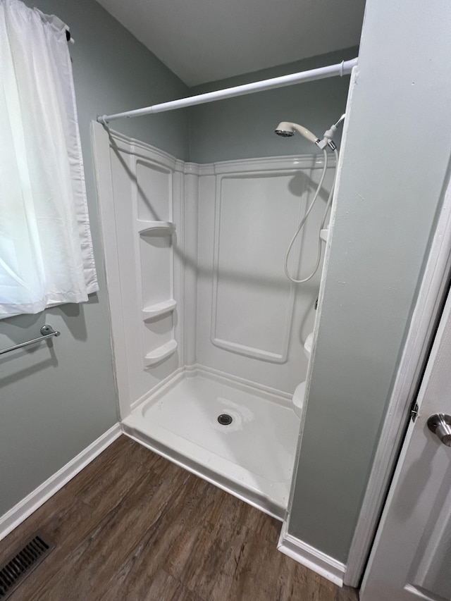 bathroom featuring hardwood / wood-style floors and walk in shower