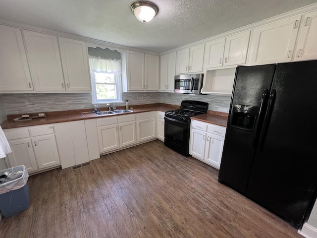 kitchen with black appliances, white cabinets, and sink