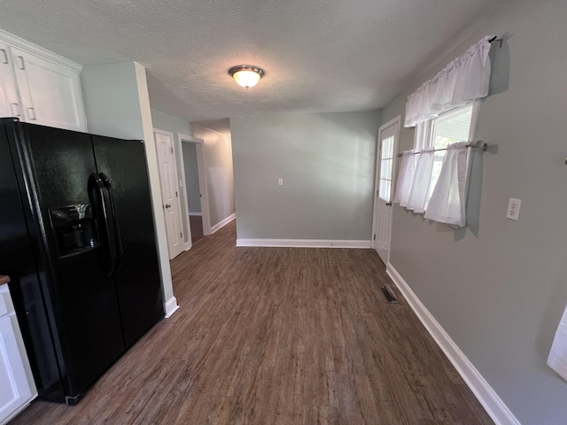 kitchen featuring white cabinets, black fridge with ice dispenser, dark hardwood / wood-style flooring, and a textured ceiling