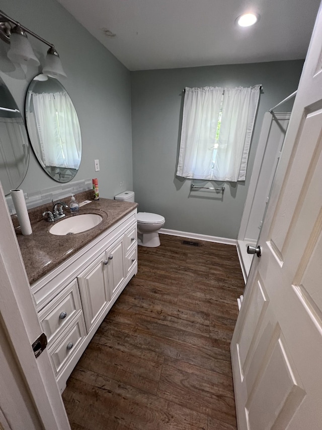 bathroom featuring hardwood / wood-style flooring, vanity, and toilet