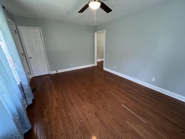 unfurnished room featuring ceiling fan, dark hardwood / wood-style flooring, and a textured ceiling