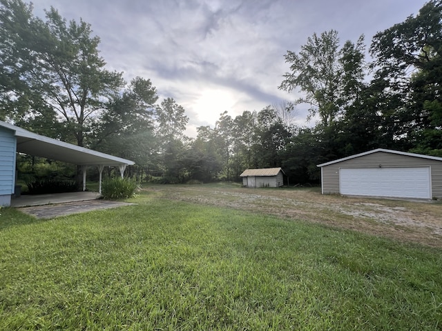 view of yard with an outbuilding, a garage, and a carport