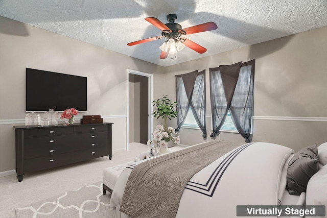 carpeted bedroom with ceiling fan and a textured ceiling