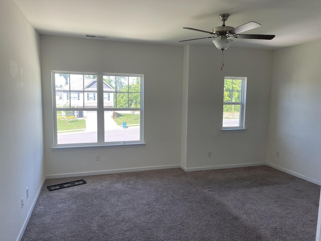 carpeted spare room featuring ceiling fan