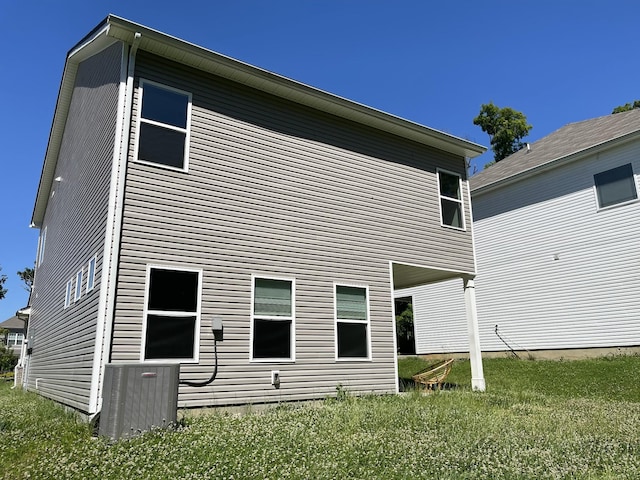 back of property featuring a yard and cooling unit