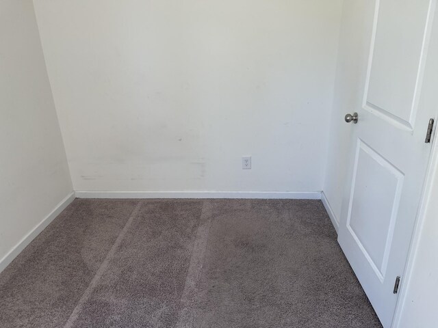 unfurnished room featuring dark carpet