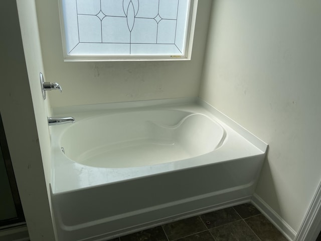 bathroom with tile patterned flooring and a tub