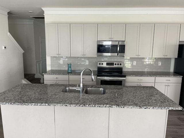 kitchen with sink, crown molding, dark stone counters, white cabinets, and appliances with stainless steel finishes