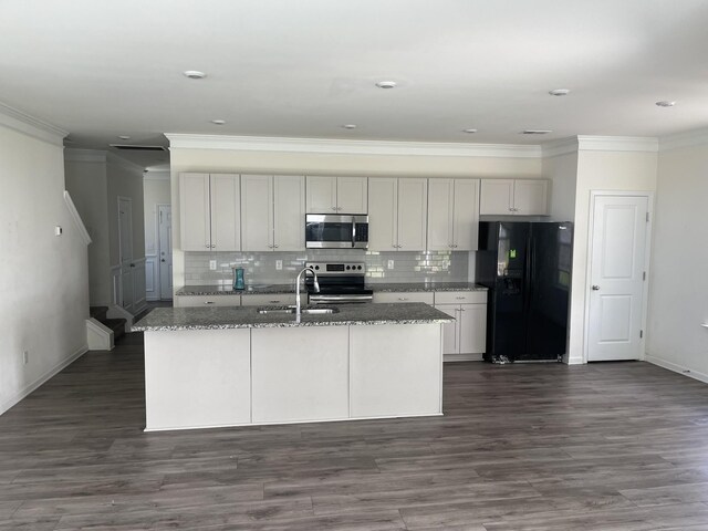 kitchen featuring appliances with stainless steel finishes, stone countertops, and an island with sink