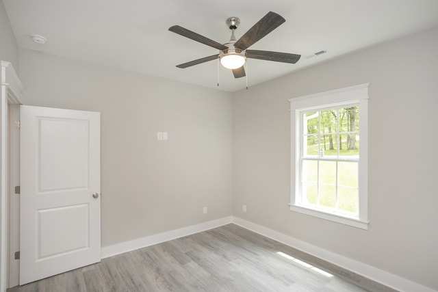 spare room with ceiling fan and light wood-type flooring