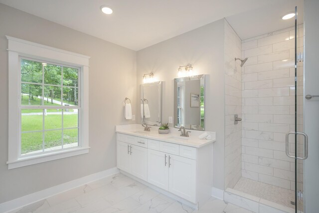 bathroom featuring double vanity, a shower with door, a healthy amount of sunlight, and tile floors