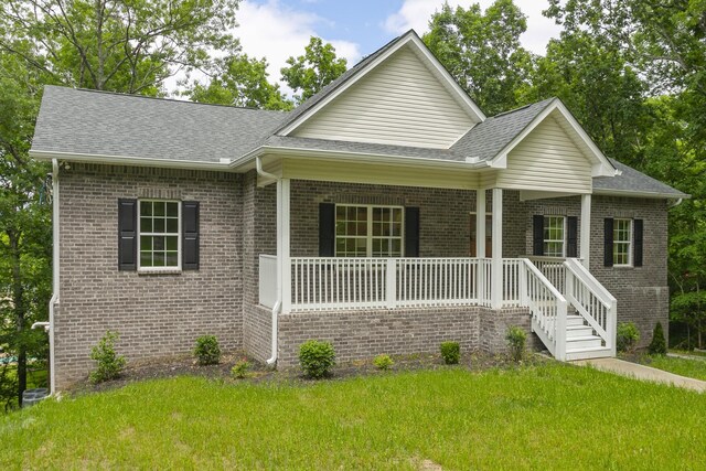 view of front facade with covered porch and a front lawn