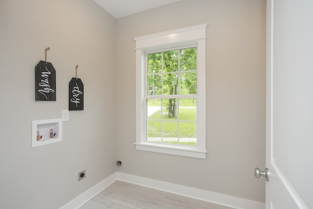 clothes washing area with a healthy amount of sunlight, hardwood / wood-style flooring, hookup for a washing machine, and electric dryer hookup