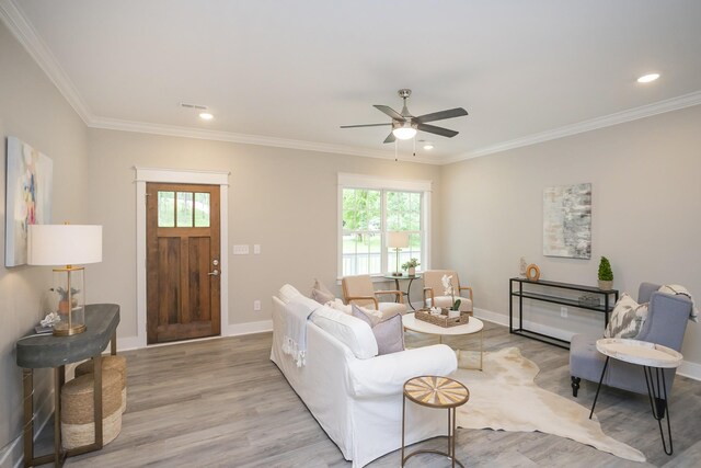 living room featuring crown molding, light wood-type flooring, and ceiling fan