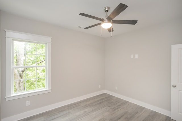 empty room featuring ceiling fan, plenty of natural light, and light hardwood / wood-style floors