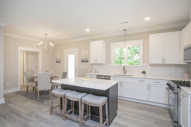 kitchen featuring white cabinetry, appliances with stainless steel finishes, sink, and light wood-type flooring