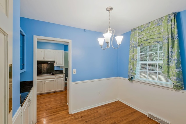 dining area featuring light hardwood / wood-style flooring and a notable chandelier