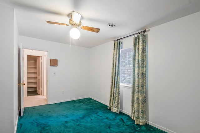 carpeted spare room with ceiling fan