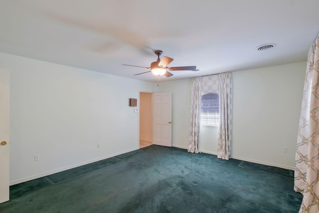 empty room with ceiling fan and dark carpet