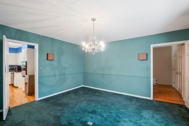 unfurnished room featuring dark carpet and a notable chandelier