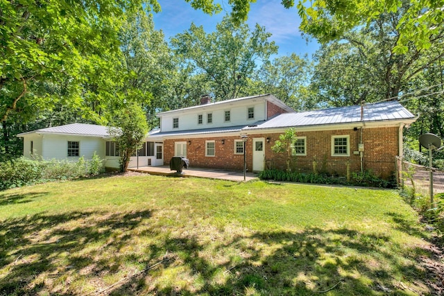 rear view of house featuring a lawn and a patio area